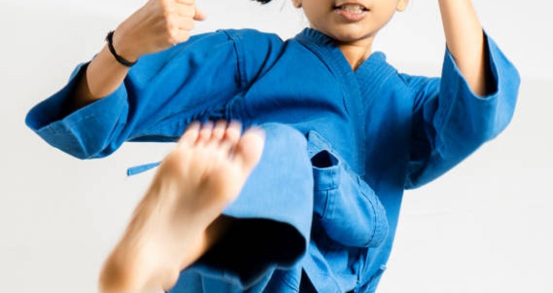 Asian girl posting Taekwondo fighting on white background