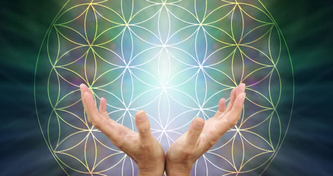 Female cupped hands reaching up inside the flower of life symbol pattern against a light to dark green radiating background with copy space above